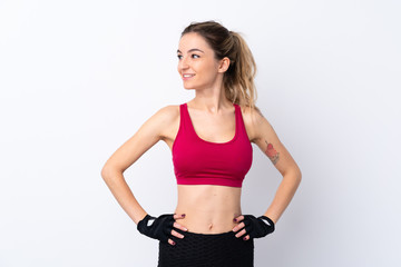 Fototapeta na wymiar Young sport woman over isolated white background posing with arms at hip and looking side