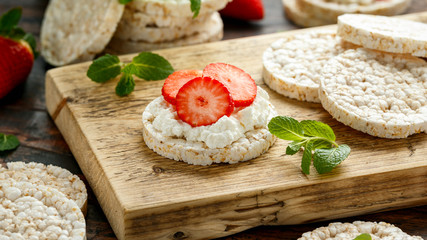 Rice crackers with ricotta and strawberries on wooden board. healthy food