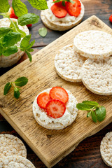 Rice crackers with ricotta and strawberries on wooden board. healthy food