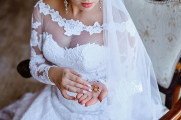 bride's wedding bands in the palm of his hand