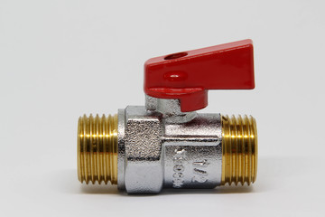 Brass ball valve with red handle on white background.