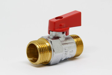 Brass ball valve with red handle on white background.