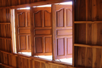 Three wooden windows on the wooden wall of a new house.