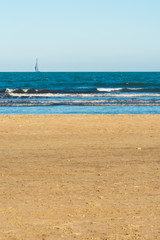 Fototapeta na wymiar Valencia Beach (Malvarrosa.) with waves and ships in the background