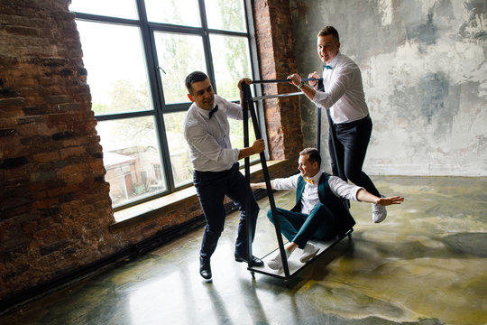 the groom and his two friends are having fun in the apartment