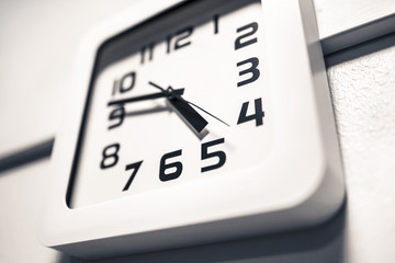 Modern clock on a wall. Almost 5 o'clock in the afternoon or morning. Over time at work. Dramatic...