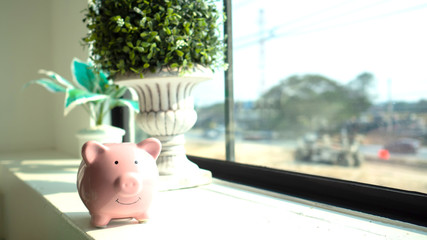 piggy bank at a window, look out the window to see the world. saving money for future concept