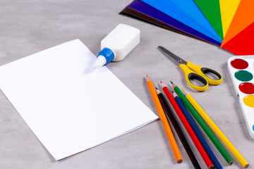 Sheets of paper, glue and scissors on a table
