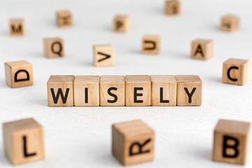 Wisely - words from wooden blocks with letters, experience, knowledge, and good judgement wisely...