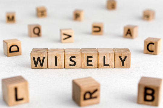 Wisely - words from wooden blocks with letters, experience, knowledge, and good judgement wisely concept, white background