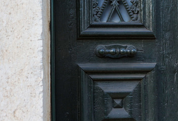 Wooden dark aged textured entrance with rings door handles and metal details. Architecture...