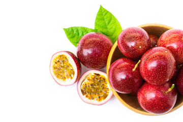 Closeup passion fruits ( Maracuya ) in wooden bowl and half slice with green leaves isolated on white background . 