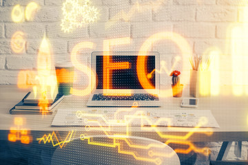 Multi exposure of table with computer and seo drawing hologram. Search optimization concept.