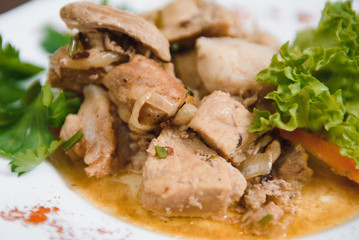 Plate of grilled beef nuggets, fried potato chips or French fries and fresh leafy green salad with cucumber on a white background