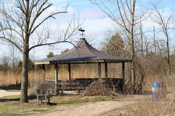 The old brown wood gazebo in the park on a sunny day.