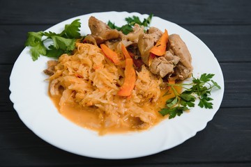 Fried cabbage in the white bowl on a rustic background