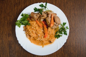 Fried cabbage in the white bowl on a rustic background