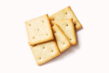 Square crispy saltine crackers isolated on white background. Flat lay food photography