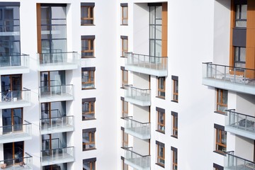 Contemporary residential building exterior in the daylight. Modern apartment buildings on a sunny day with a blue sky. Facade of a modern apartment building