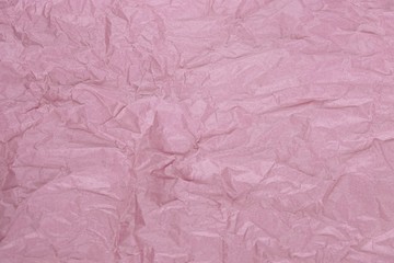 Crumpled pale pink tissue paper for background or gift wrapping. Abstract textured wrinkled faded rose parchment backdrop.Surface of bleached pink wrapping paper with creases texture for background.