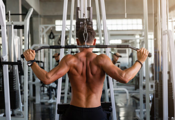 Muscular young man doing workout with weight lifting equipment in the sport gym, training hard in the gym, Athlete makes exercise, Bodybuilder, Sport fitness and muscles concept