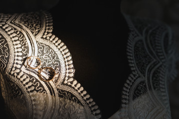 Fototapeta na wymiar Beautiful wedding gold rings on dark background