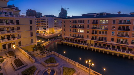 Canal aerial top view in Venice-like Qanat Quartier of the Pearl precinct of Doha day to night timelapse, Qatar.