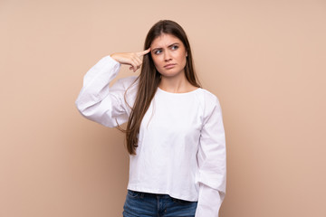 Young girl over isolated background making the gesture of madness putting finger on the head