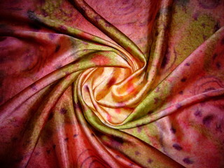 Red silk fabric with drapery. The texture of the fabric. Natural silk. Silk scarf, silk scarf.