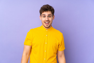 Caucasian man isolated on purple background with surprise facial expression