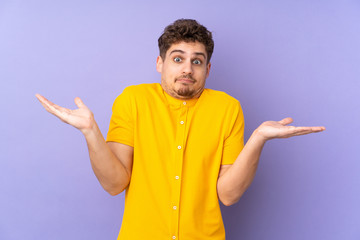 Fototapeta premium Caucasian man isolated on purple background making doubts gesture