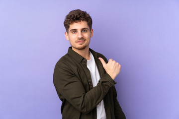 Caucasian man isolated on purple background proud and self-satisfied