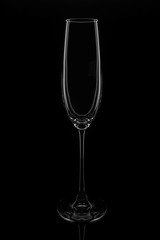 Empty champagne glass on a black background, elegantly illuminated on the sides. Concept, mysterious club life.