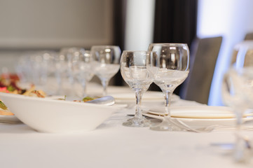 Glasses on the festive table setting. Wedding table decor concept. Table setting in classic style, setout. fine art.