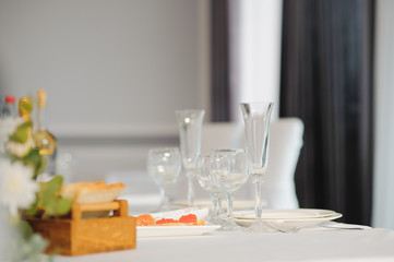 Glasses on the festive table setting. Wedding table decor concept. Table setting in classic style, setout. fine art.