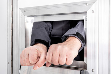Straftäter beim Gefangenentransport mit Händen aus der Zelle für Handschellen
