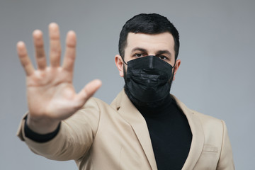 Man with arm outstretched forward. Copy space for your text. People in masks. The outbreak of Novel Corona virus. Air pollution, Environmental awareness concept