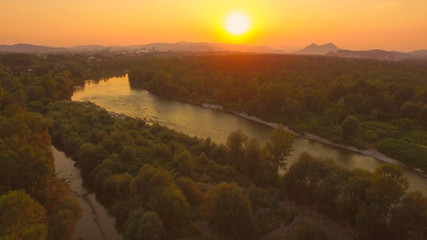 AERIAL: Beautiful wide river with tributary at magical golden light sunset