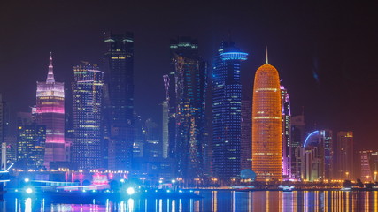 Traditional dhow boat in Doha at night timelapse, with modern buildings in the