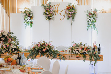 Floral wedding decoration. Wedding table setting decorated with fresh flowers. Wedding floristry. Bouquet with roses, eustoma and eucalyptus leaves.