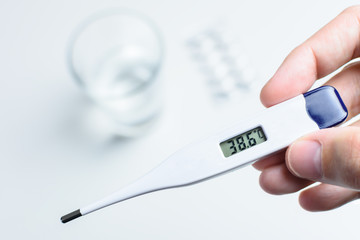 caucasian man checking fever with a thermometer