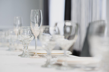 Glasses on the festive table setting. Wedding table decor concept. Table setting in classic style, setout. fine art.