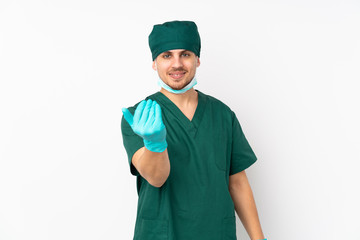 Surgeon in green uniform isolated on isolated white background inviting to come with hand. Happy that you came