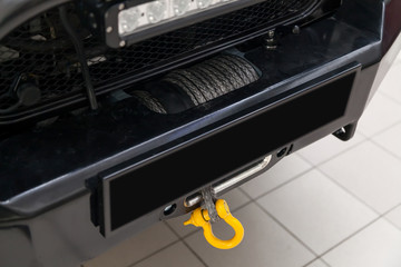 A towing winch with a shackle and a loop on a metal cable mounted on a car for pulling out and evacuating vehicles. Overcoming off-road and extreme racing. © Aleksandr Kondratov