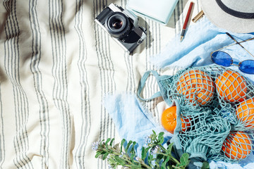 Feminine summer picnic flatlay, fruits, berries and lemon water on striped cotton blanket