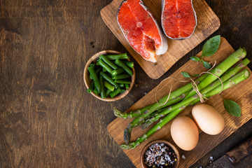 Organic food. Healthy food cooking concept. Salmon, asparagus and eggs on a rustic table. Top view flat lay background. Copy space.