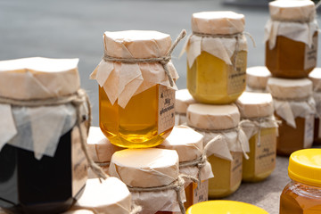 Light honey in a glass jar. Jars full of fresh honey are for sale.