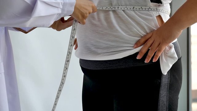 Physical doctor man with measure tape consult for weight loss obesity 