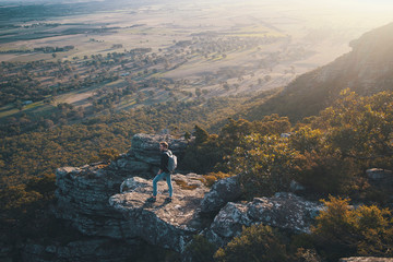 Young man hiking on cliff at Grampians National Park Australia