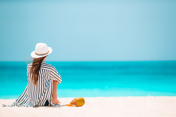 Fototapeta na wymiar Young woman on white beach with coconut
